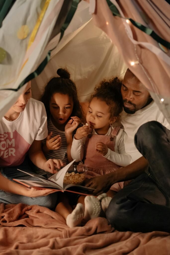 A diverse family enjoys a cozy story session in a blanket fort, creating memorable moments.